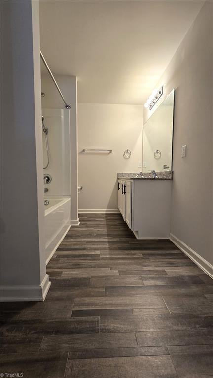 bathroom with hardwood / wood-style flooring, vanity, and  shower combination