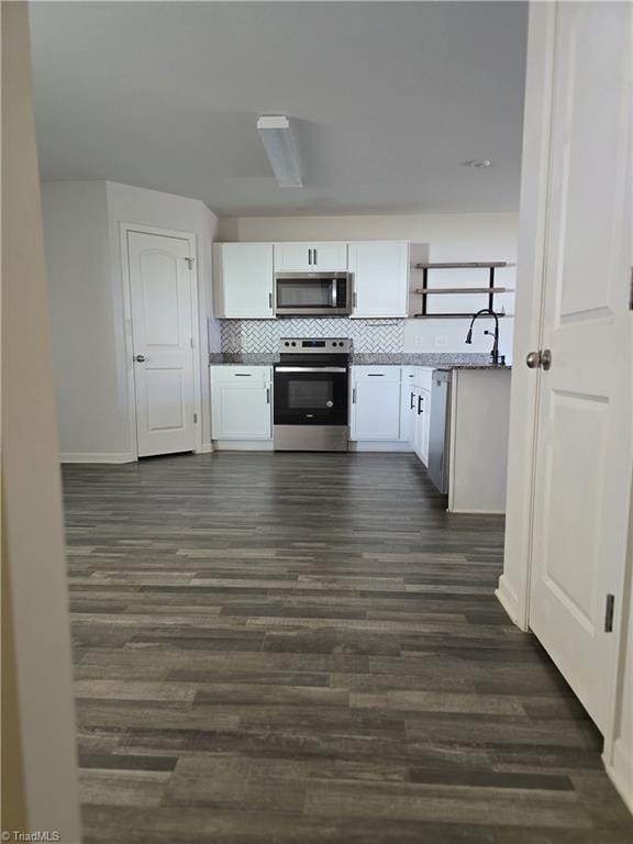 kitchen with tasteful backsplash, dark hardwood / wood-style floors, stainless steel appliances, and white cabinetry