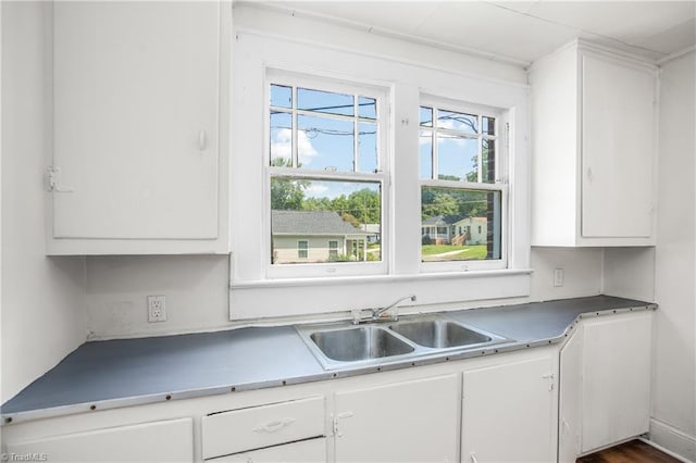 kitchen featuring sink, dark hardwood / wood-style flooring, white cabinetry, and a healthy amount of sunlight