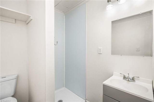 bathroom featuring vanity, walk in shower, and toilet