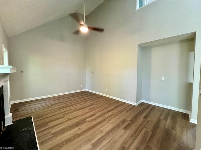 unfurnished living room with a ceiling fan, dark wood-type flooring, high vaulted ceiling, a fireplace, and baseboards