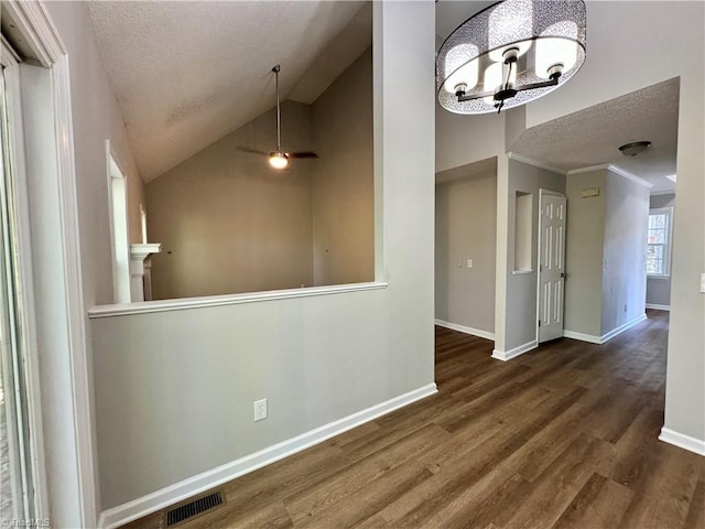 unfurnished dining area featuring a textured ceiling, wood finished floors, baseboards, vaulted ceiling, and a chandelier