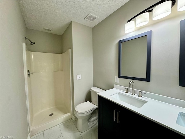 bathroom with vanity, a textured ceiling, toilet, and walk in shower