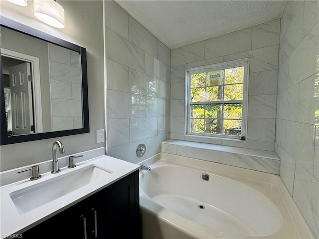 bathroom featuring vanity, a tub to relax in, and a textured ceiling