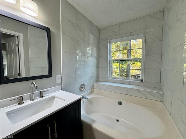 bathroom featuring a textured ceiling, a bath, and vanity