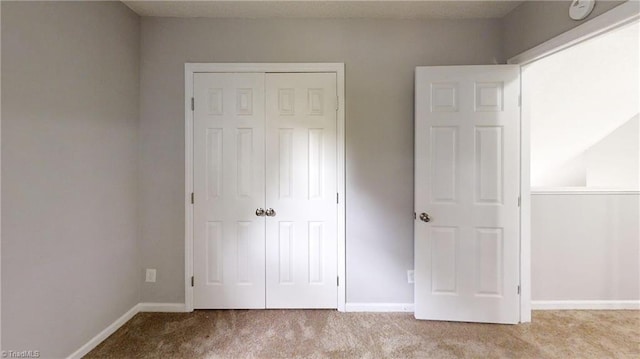 unfurnished bedroom with light carpet and a closet