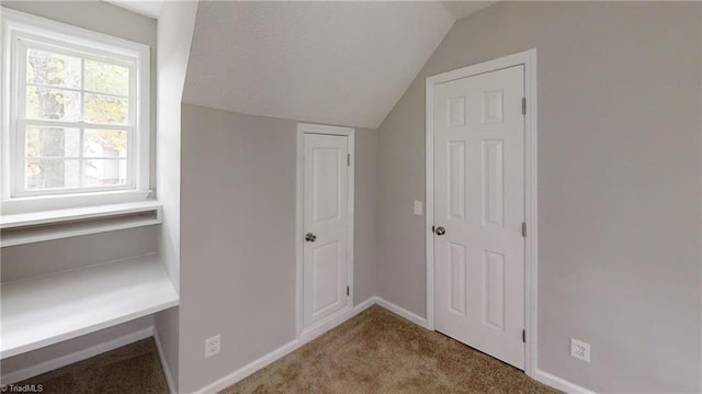 interior space featuring lofted ceiling and light colored carpet