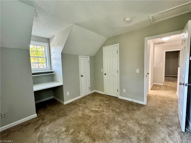 bonus room with a textured ceiling, carpet floors, baseboards, and vaulted ceiling