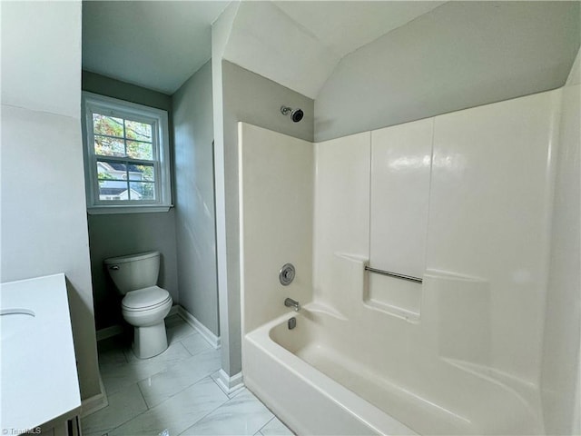 bathroom featuring toilet, marble finish flooring, lofted ceiling, shower / bathtub combination, and baseboards