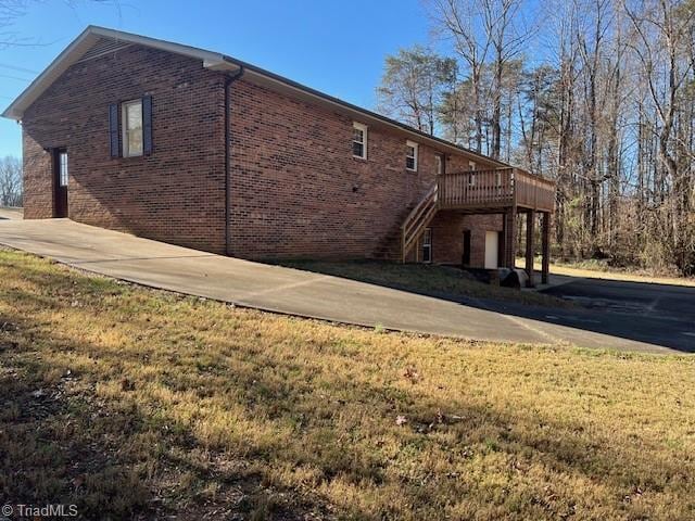 view of side of property with a yard and a wooden deck