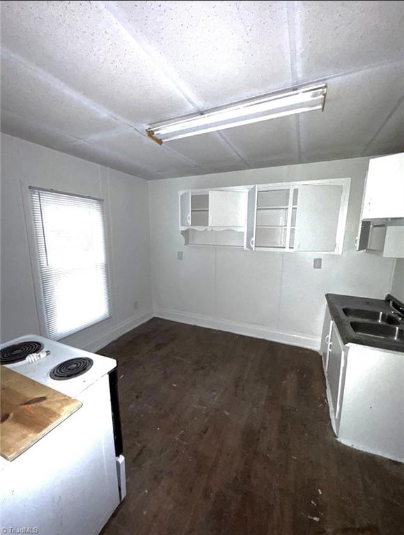 kitchen featuring white range with electric cooktop, dark hardwood / wood-style floors, a textured ceiling, and sink