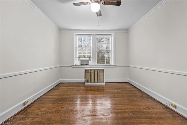 empty room featuring ornamental molding, dark wood-style flooring, baseboards, and radiator heating unit