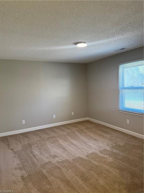 carpeted spare room with a textured ceiling