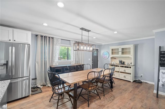 dining area with light wood-style flooring, baseboards, ornamental molding, and recessed lighting