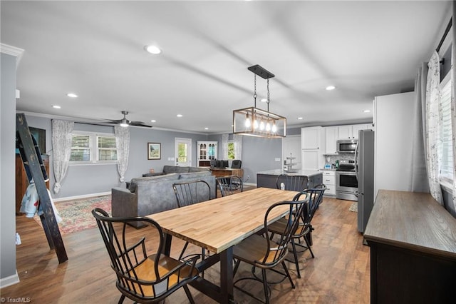 dining space with baseboards, ornamental molding, recessed lighting, and wood finished floors