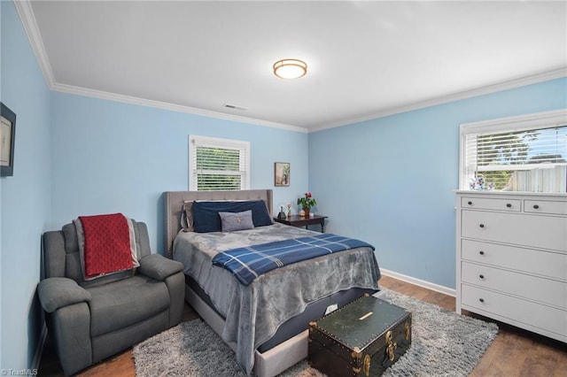 bedroom featuring visible vents, wood finished floors, baseboards, and ornamental molding