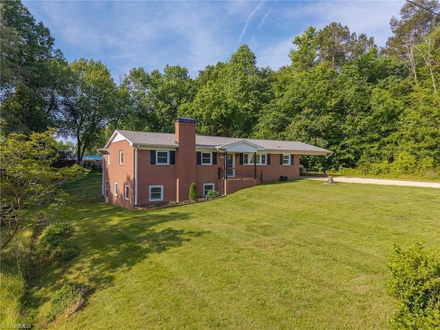 view of front of house featuring a front lawn, brick siding, and a chimney