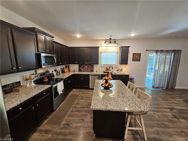 kitchen with a wealth of natural light, a breakfast bar area, stainless steel appliances, and a kitchen island