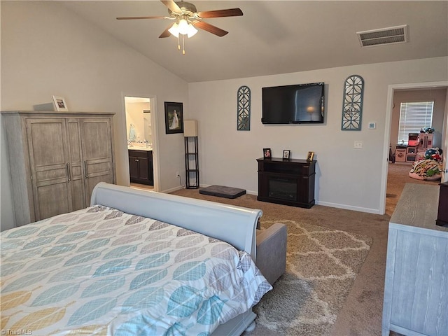 bedroom with light carpet, connected bathroom, lofted ceiling, and ceiling fan