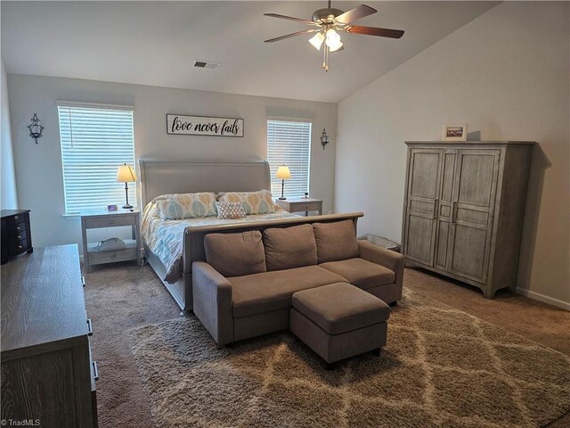 carpeted bedroom with ceiling fan and vaulted ceiling