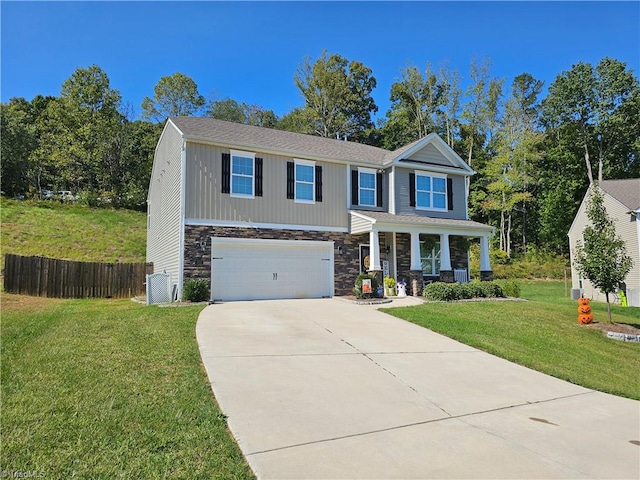 view of front of home with a garage, covered porch, and a front yard