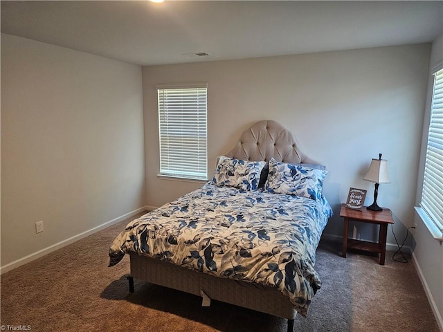 bedroom with multiple windows and dark colored carpet