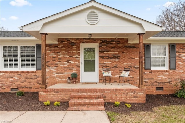 view of front of home with crawl space, a porch, a shingled roof, and brick siding