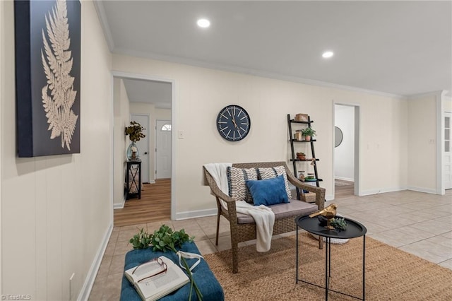 sitting room with light tile patterned floors, recessed lighting, crown molding, and baseboards