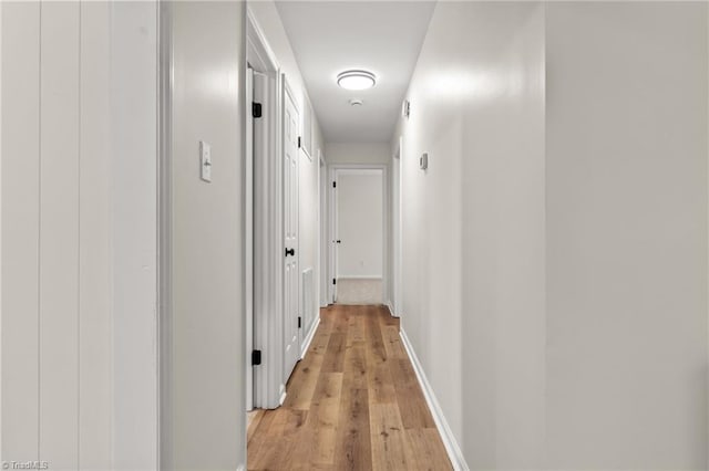 hallway with baseboards and light wood-style floors