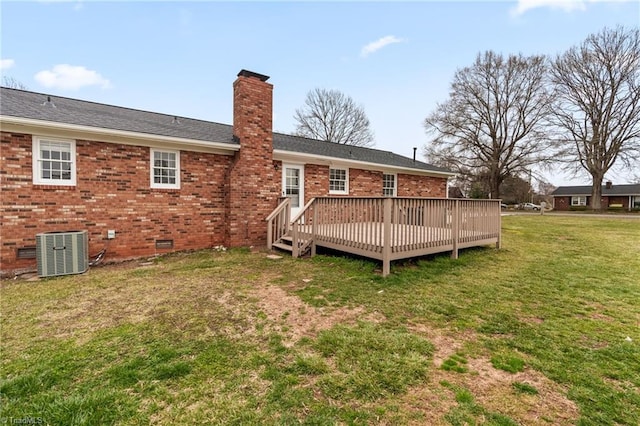 rear view of house with cooling unit, a yard, a chimney, crawl space, and brick siding