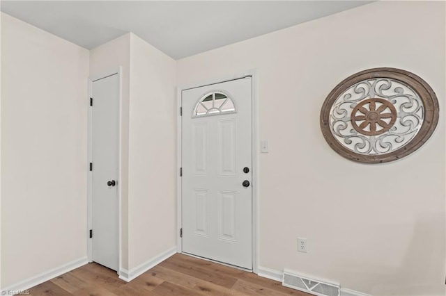 foyer entrance with light wood finished floors, visible vents, and baseboards