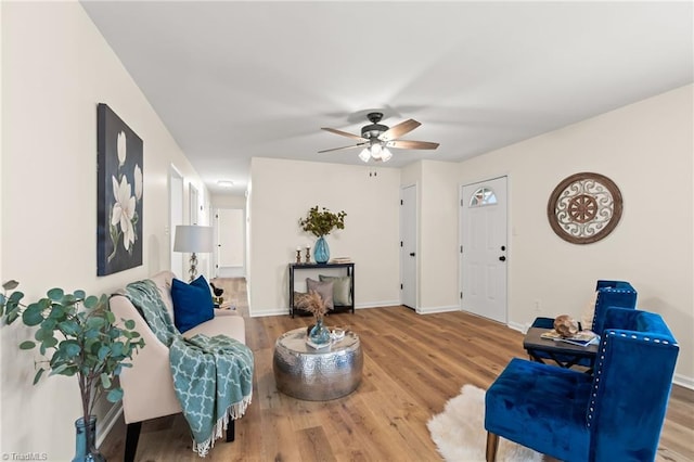 interior space featuring a ceiling fan, baseboards, and wood finished floors