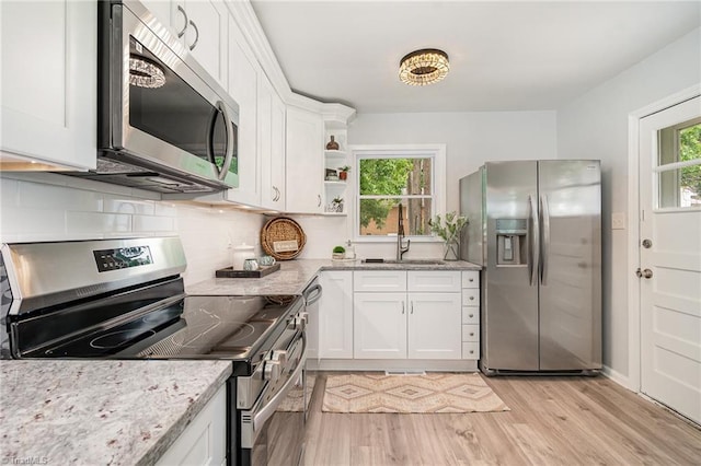 2102 Castlerock Rd, Greensboro, NC 27406 - kitchen with appliances with stainless steel finishes, a sink, plenty of natural light, and light wood-style flooring
