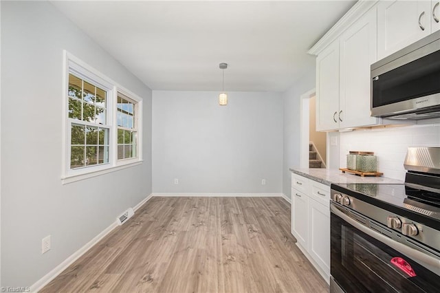 2102 Castlerock Rd, Greensboro, NC 27406 - kitchen with appliances with stainless steel finishes, decorative backsplash, light wood-style floors, white cabinets, and baseboards
