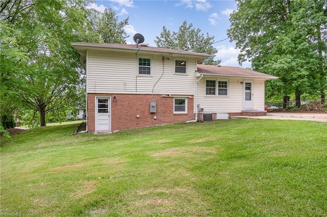 2102 Castlerock Rd, Greensboro, NC 27406 - rear view of property featuring central AC, brick siding, and a yard
