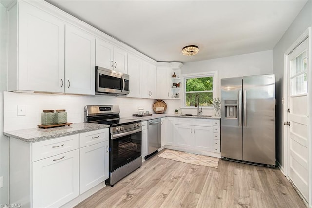 2102 Castlerock Rd, Greensboro, NC 27406 - kitchen with appliances with stainless steel finishes, light wood-style flooring, open shelves, a sink, and white cabinets