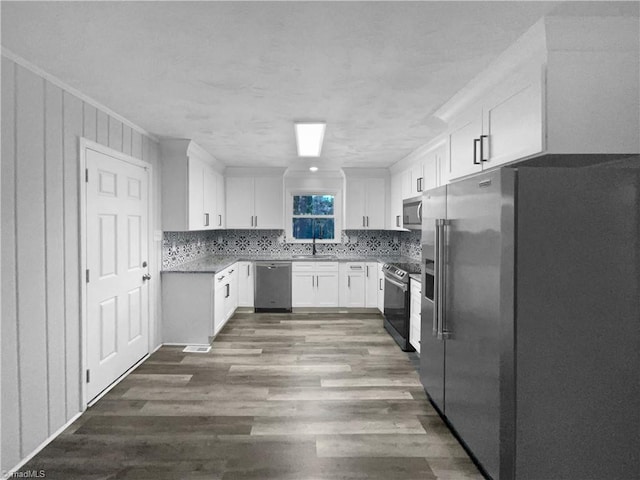 kitchen featuring sink, dark wood-type flooring, stainless steel appliances, and white cabinets