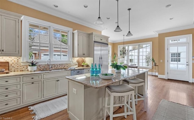 kitchen featuring tasteful backsplash, built in fridge, ornamental molding, and a sink