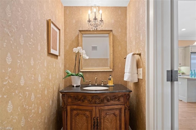 bathroom featuring wallpapered walls, vanity, and wood finished floors