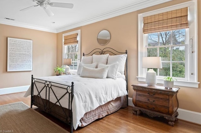 bedroom featuring crown molding, multiple windows, wood finished floors, and visible vents