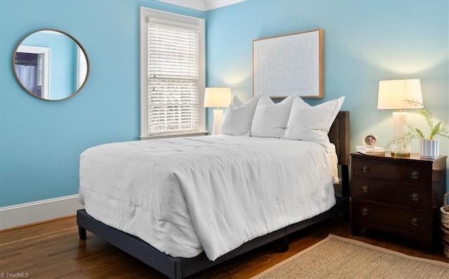 bedroom featuring baseboards and wood finished floors