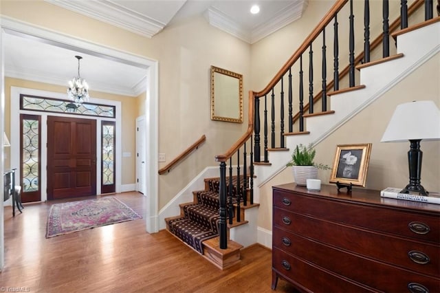 foyer with crown molding, wood finished floors, and baseboards