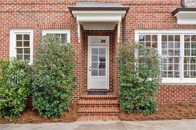 view of exterior entry with brick siding