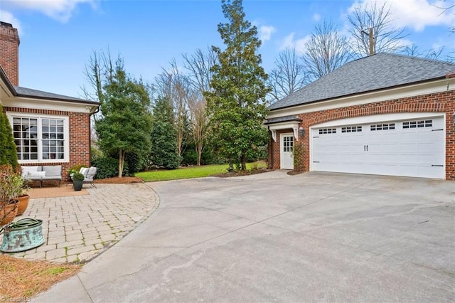 view of home's exterior featuring brick siding, an attached garage, concrete driveway, and a shingled roof