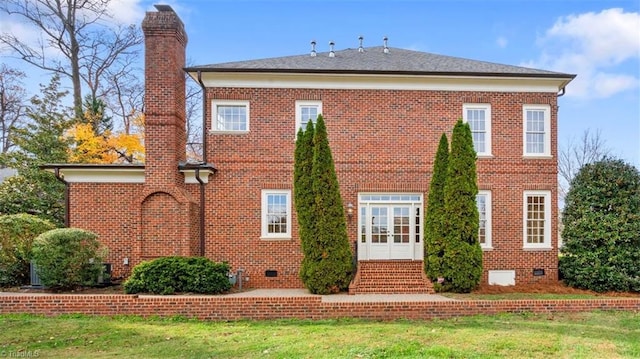 back of house with crawl space, brick siding, a chimney, and entry steps