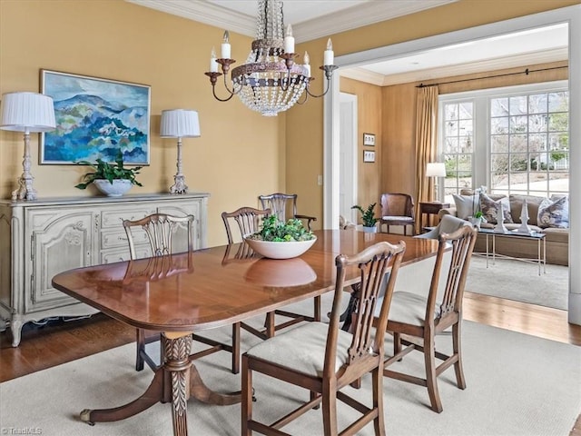 dining room featuring a chandelier, wood finished floors, and crown molding