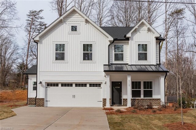 modern inspired farmhouse with a garage and a front yard