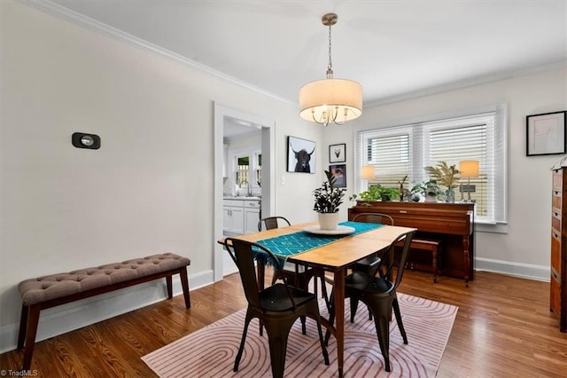 209 Burtner St, Greensboro, NC 27406 - dining space with baseboards, wood finished floors, crown molding, and a chandelier