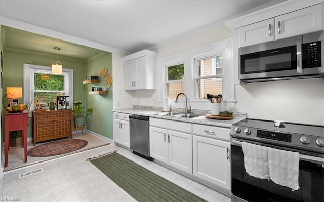209 Burtner St, Greensboro, NC 27406 - kitchen featuring stainless steel appliances, a sink, ornamental molding, light countertops, and white cabinetry