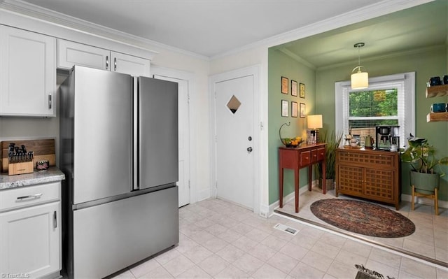 209 Burtner St, Greensboro, NC 27406 - kitchen with freestanding refrigerator, white cabinetry, ornamental molding, decorative light fixtures, and baseboards